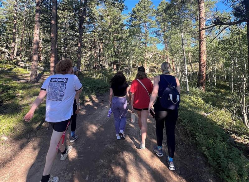 group of five shot from behind, walking through woods